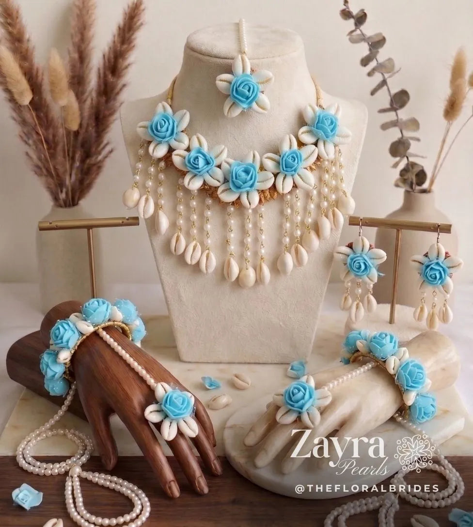 Handcrafted aqua haldi floral set for brides displayed beautifully on a luxury linen background showing the choker necklace, maang tikka, and earrings.