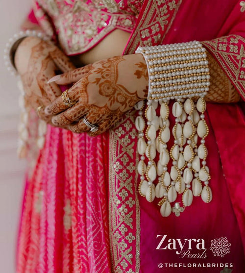 Close-up of a bride's hands adorned with intricate henna designs, a pearl-heavy bangle by Zayra Pearls
