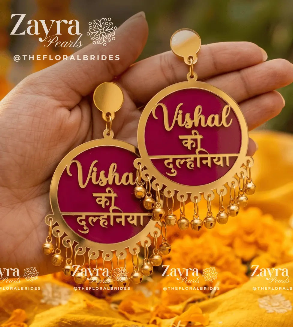 Close-up display of bespoke script reading Dulhan ki Bhabhi and hanging ghoongroo bells on Golden Aura custom earrings.