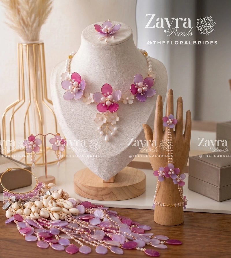 Handcrafted pink and purple floral viral haldi jewelry set with necklace earrings hathphool maangtikka and kaleere by Zayra Pearls.