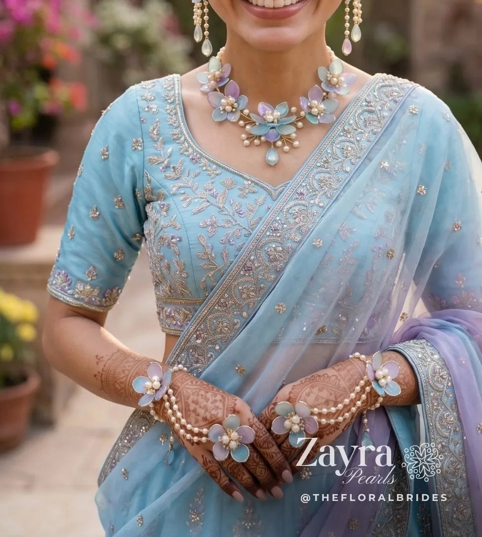 Woman wearing a light blue saree with Close-up texture of the hand-crafted left and right hand harness haathphools from our premium Resin Carnival Haldi Jewelry collection by zayra pearls